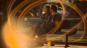 tarot-lovers-two-of-pentacles-couple-park-bench-coins-carousel-circles-lens-flare