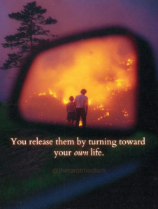 You release them by turning toward your own life. Two human figures with their backs facing forward seen in a rearview mirror surrounded by fire and blaze, symbolizing the spiritual act of releasing someone by becoming present in your own life, explained by Chris Bennett, the best tarot reader and psychic medium.