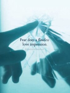 A finger touching a cracked mirror, carrying the quote "Fear does a flawless love impression." From The Tarot Medium on the signs of attachment vs love.